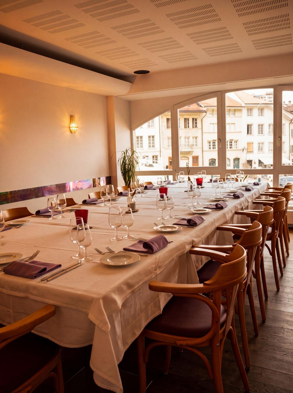 La salle des arcades, tables en longueur sous les baies cintrées